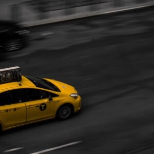 a yellow taxi cab driving down a street